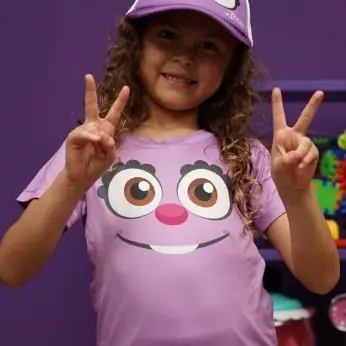 Niña con camiseta morada con la cara de Pitzy