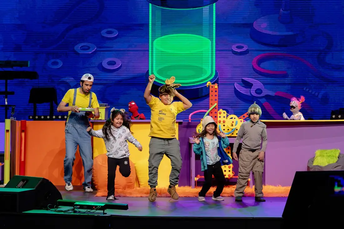 Niños bailando en el escenario junto al elenco del show de Los Mizzu